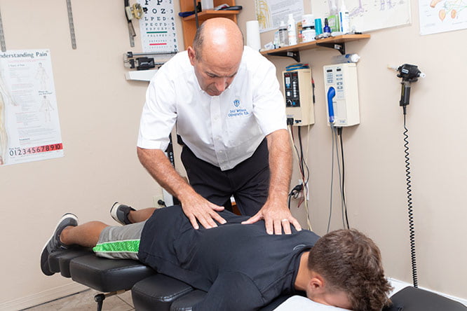 Dr Sam Strickland working on a patient's back.